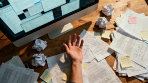 Escritorio desordenado con tickets y papeles esparcidos.